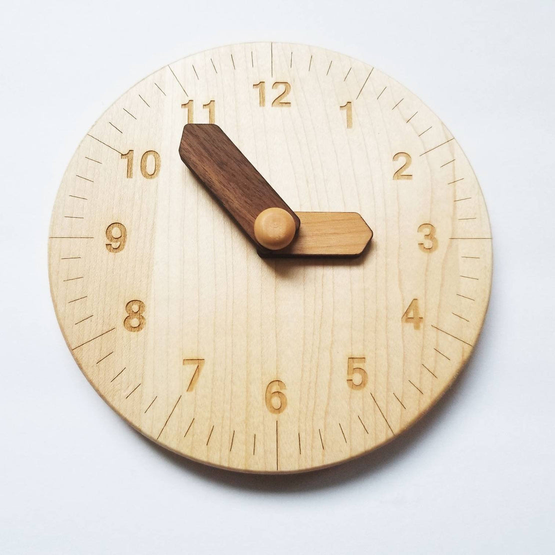 Wooden toy clock with minute and hour in different shades for easy learning